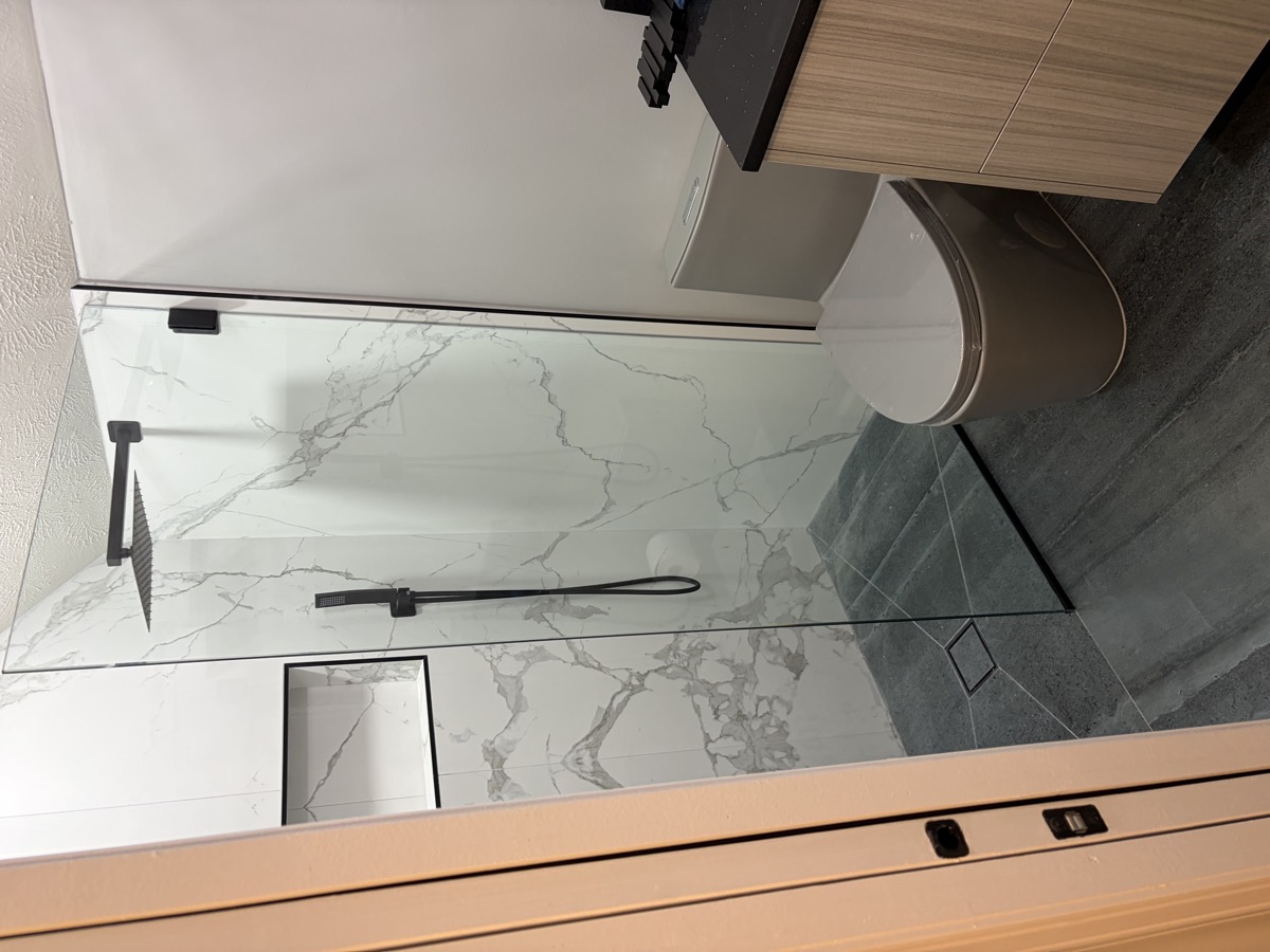 Showcase frameless shower enclosure