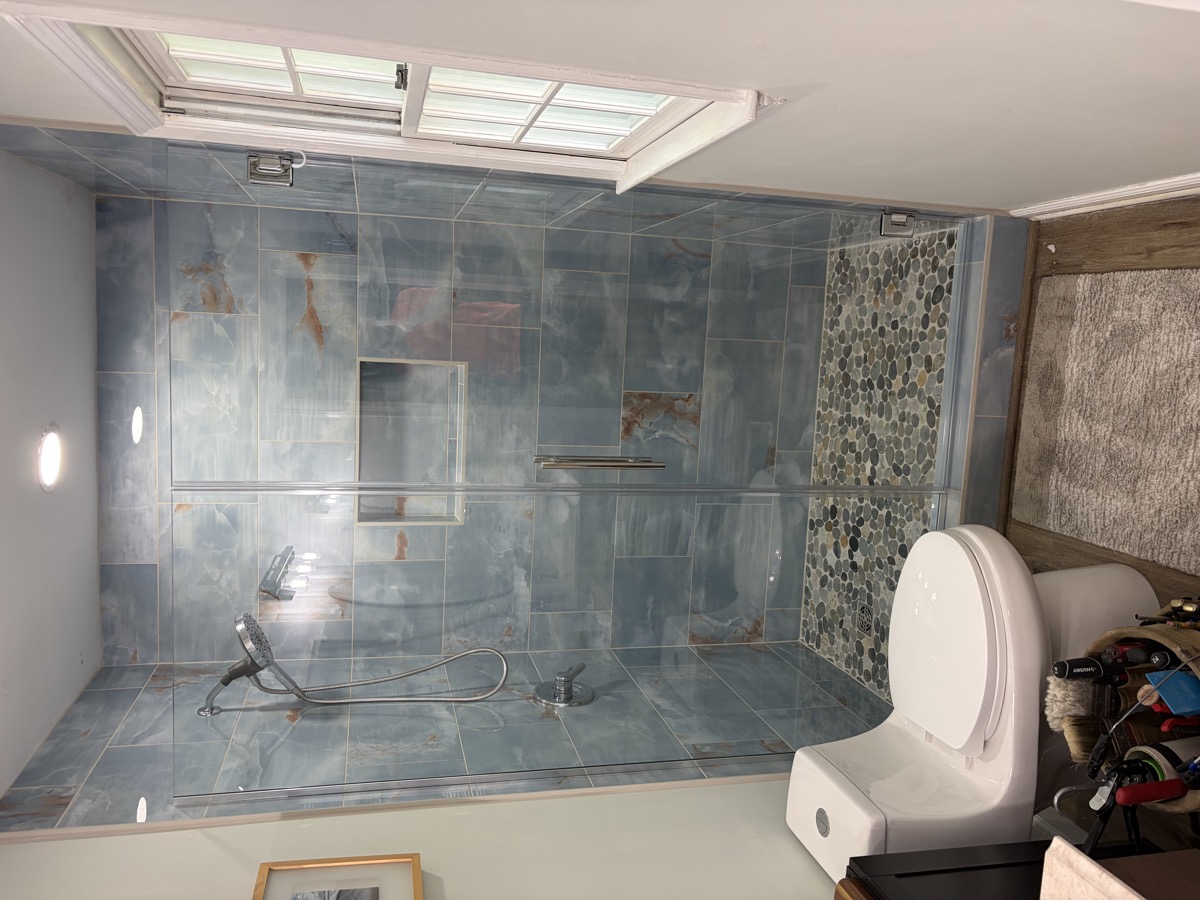 Custom glass shower door with polished hardware